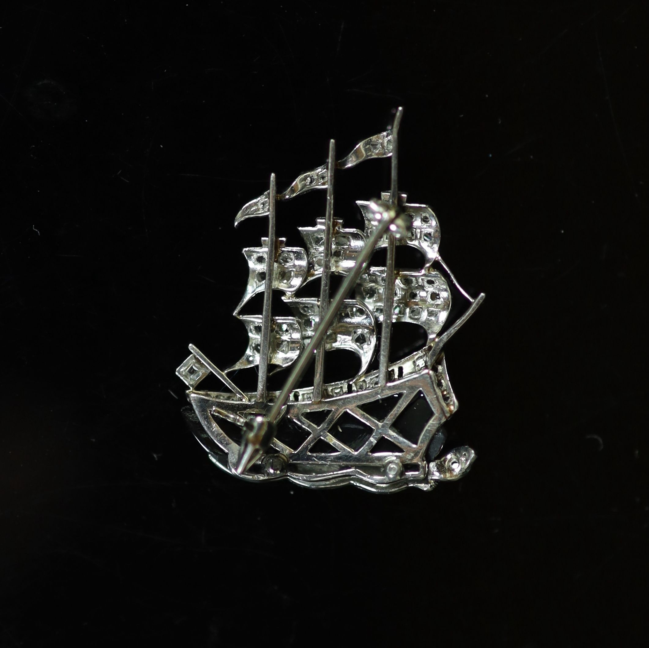 A modern white gold, black enamel and diamond chip set brooch, modelled as a three masted sailing ship